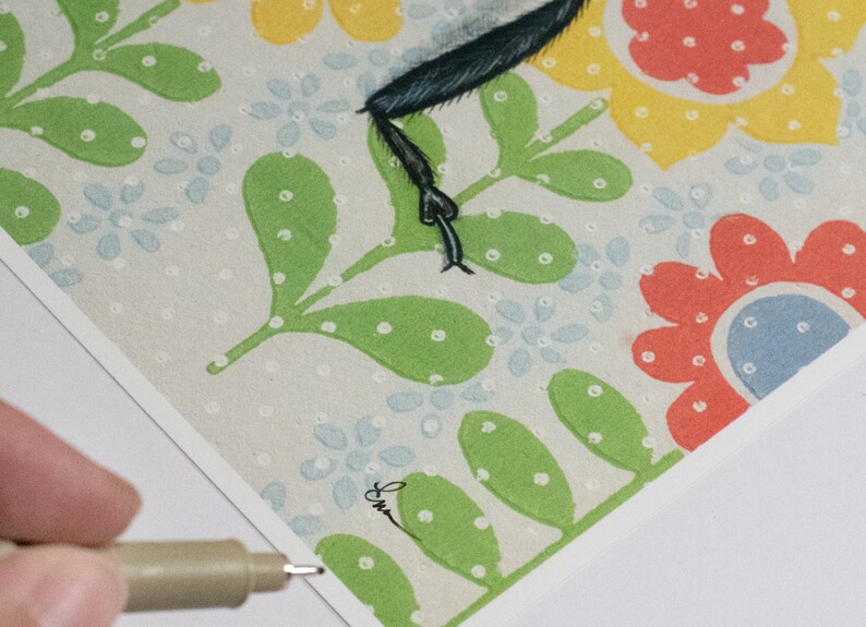 May include: A close-up of a colorful floral print with green leaves and white dots. The print features a black and white illustration of a bird with a long, thin leg.
