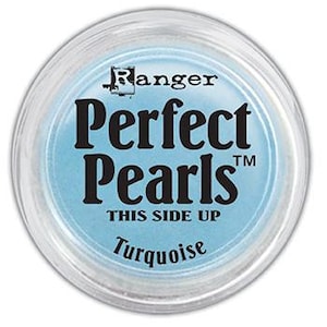 May include: A small round jar of turquoise blue Perfect Pearls pigment, a brand of mica powder for crafting and art projects. The jar has a clear lid and the label reads "Ranger Perfect Pearls™ This Side Up Turquoise".
