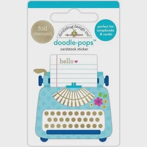 May include: A cardstock sticker featuring a light blue typewriter design with gold and white accents. The sticker includes the text "hello" and is foil stamped. The packaging also states it is perfect for scrapbooks and cards.