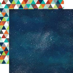 May include: Double-sided scrapbook paper. One side has a dark blue watercolour background with white speckles, resembling a starry night sky. The other side has a colourful geometric pattern of triangles in orange, green, blue, and grey.