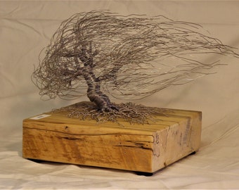 Escultura de árvore varrida pelo vento em aço inoxidável torcido e enrolado em madeira de celeiro espalhada