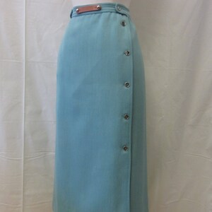 May include: A light blue skirt with a brown leather belt and silver button accents.