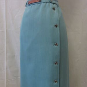 May include: A light blue skirt with a brown leather belt and silver buttons down the side.