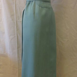 May include: A light blue skirt with a high waist and a straight cut. The skirt is made of a smooth fabric and has a simple design.