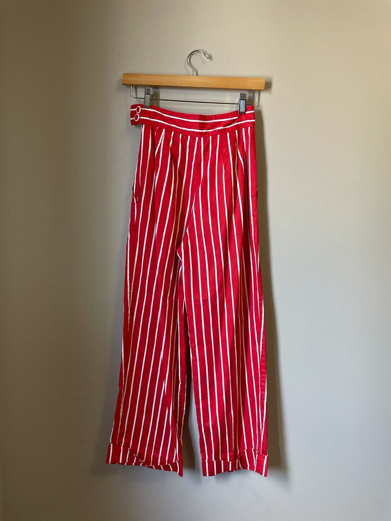 May include: Red and white striped wide-leg pants with a button closure at the waist.