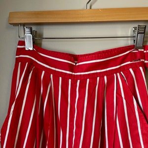 May include: Red and white striped high-waisted shorts with a wide waistband and pleats.