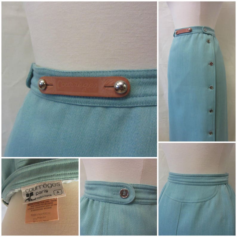 May include: A light blue skirt with a brown leather belt and silver buttons. The belt has the text "Courreges Paris" embossed on it. The skirt has a side zipper and a side slit.