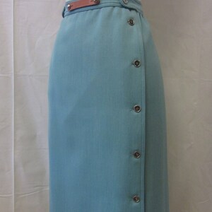 May include: A light blue skirt with a brown leather belt and silver buttons. There is a small area of discoloration on the skirt.