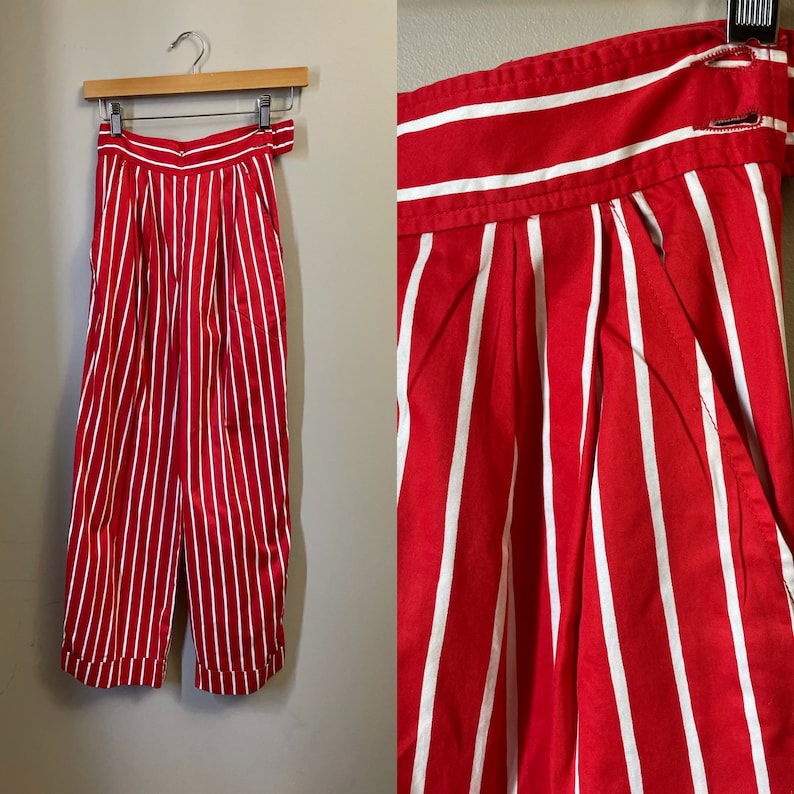May include: Red and white striped pants with a high waist and pleats. The pants are made of a lightweight fabric and have a relaxed fit.