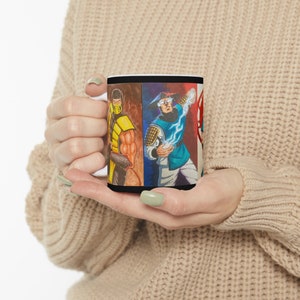 May include: A white ceramic mug with a black handle. The mug features a colorful illustration of four characters from a video game. The characters are wearing different colored outfits and have different facial expressions. The mug is a great gift for fans of the game.
