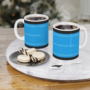 May include: Two white coffee mugs with black handles. The mugs have a blue background with black text that reads "java download in progress", "java download %50", and "java download 504 error".