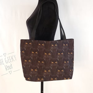 Black cats with yellow eyes tote bag