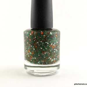 May include: A bottle of green nail polish with orange and white glitter.