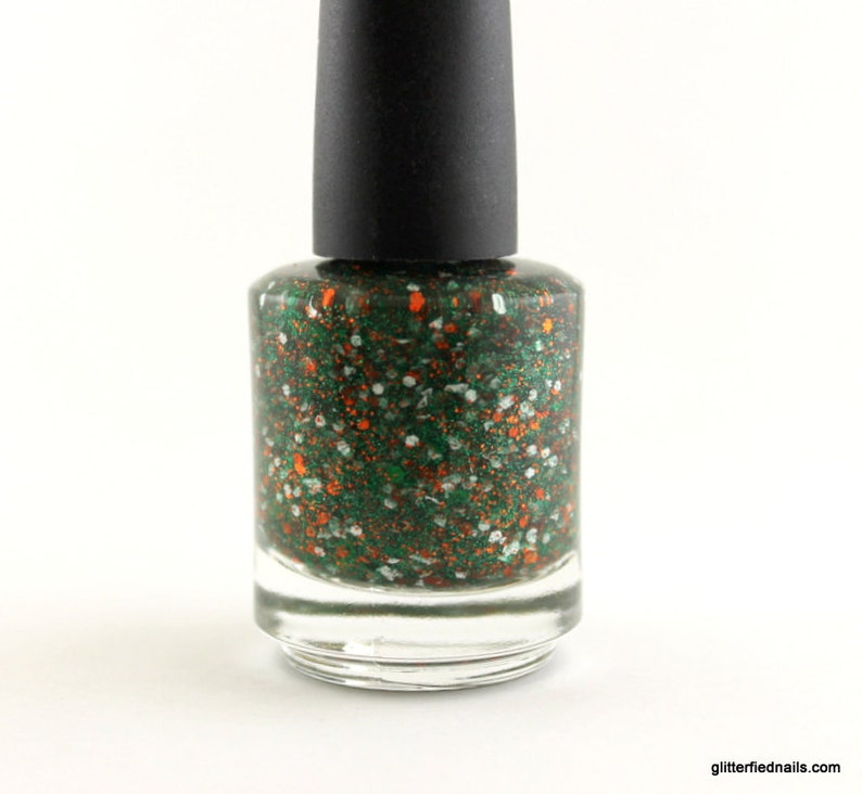 May include: A bottle of green nail polish with orange and white glitter.