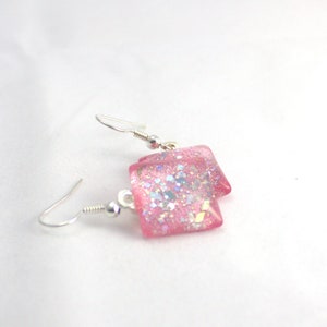 May include: Pink square earrings with silver hooks and iridescent glitter embedded in the resin.
