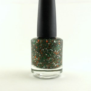 May include: A bottle of green nail polish with orange and white glitter. The bottle has a black cap.
