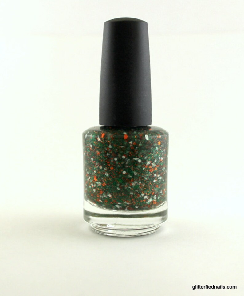 May include: A bottle of green nail polish with orange and white glitter. The bottle has a black cap.
