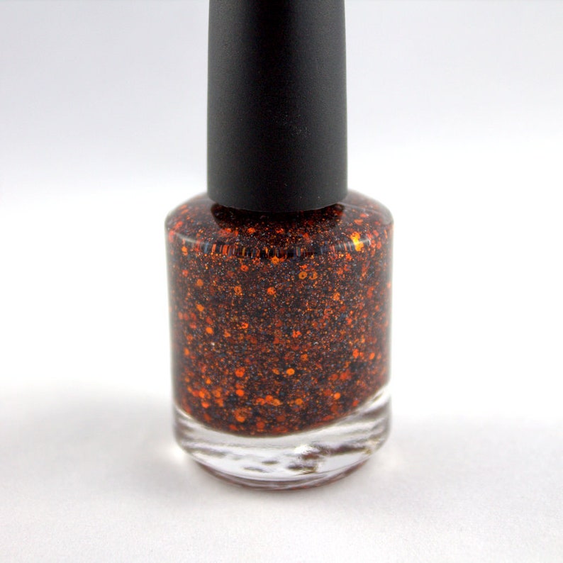 May include: A bottle of orange glitter nail polish with a black cap.