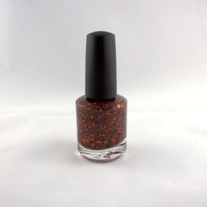 May include: A bottle of orange glitter nail polish with a black cap.