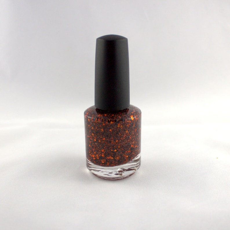 May include: A bottle of orange glitter nail polish with a black cap.