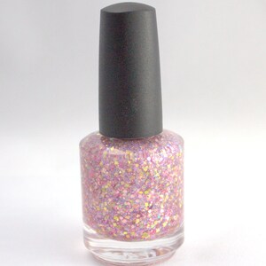 May include: A bottle of pink glitter nail polish with a black cap.
