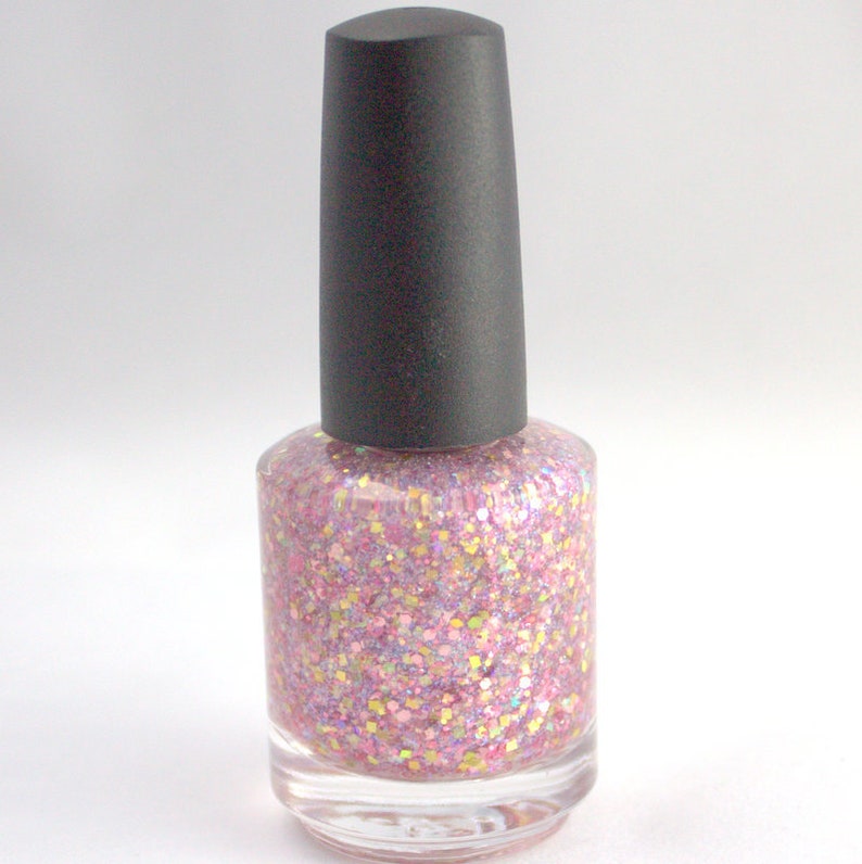 May include: A bottle of pink glitter nail polish with a black cap.