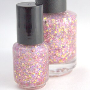 May include: Two bottles of pink glitter nail polish with black caps. The bottles are clear and show the glitter inside.