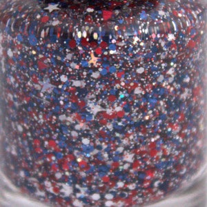 Peut inclure: Gros plan sur un flacon de vernis &agrave; ongles avec une finition paillet&eacute;e rouge, blanche et bleue.
