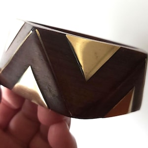 May include: A white ceramic mug with a black handle and the text "But First, Coffee" in a bold, black font. The mug is set against a blurred background, highlighting its simple design.