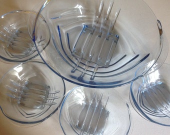 May include: Set of five clear glass bowls with a light blue tint and a geometric design. The bowls are nested together, with the largest bowl on top.