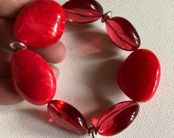 Bracelet  - pretty marbled plastic beaded elasticated bracelet large red opaque and transparent pebble shaped beads