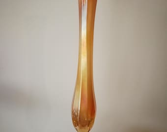 May include: An iridescent orange glass vase with a slender, elongated shape. The vase has a flared top and a round base. The glass has a textured, rippled appearance, and the vase is approximately 10 inches tall.