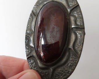 vintage Oval Arts & Crafts style pewter brooch featuring a large, domed brownish purple cabochon stone could be Ruskin