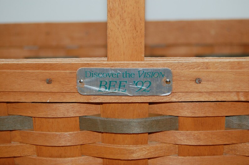 May include: A wooden basket with a metal tag that reads "Discover the Vision BEE '92".