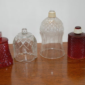 May include: Four glass candle holders, two are clear and two are a deep red color. All have a diamond pattern.