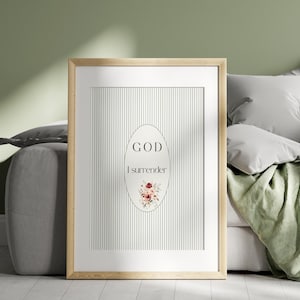 Puede incluir: Impresión artística enmarcada con un marco de madera clara. La obra presenta un fondo de rayas verticales con una forma ovalada en el centro. El óvalo contiene las palabras "GOD I surrender" y un arreglo floral.