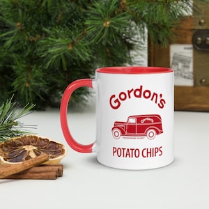 May include: White ceramic mug with a red interior and handle. The mug features the words "Gordon's POTATO CHIPS" in red, along with a vintage truck graphic. The text "TRUCKS SERVING THE BEST" is also included.