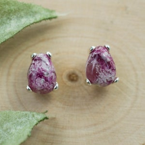 Puede incluir: Un par de pendientes de plata con piedras en forma de lágrima de color rosa y blanco.