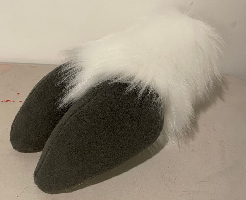 Puede incluir: Un par de orejas de felpa gris con un borde de pelo blanco y esponjoso. Las orejas est&aacute;n cosidas juntas en la base y est&aacute;n dise&ntilde;adas para ser usadas como un accesorio de disfraz.
