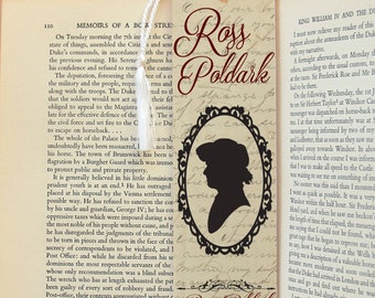 May include: A vintage bookmark with a silhouette of a woman wearing a hat and the text "Ross Poldark" in a decorative frame. The bookmark is printed on aged paper with a distressed look.