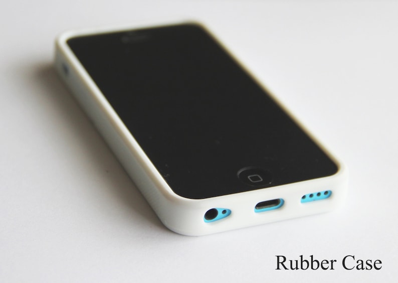 Pu&ograve; includere: Una custodia per telefono in gomma bianca con schermo nero. La custodia ha accenti azzurri attorno alle porte e un bordo bianco. Il testo "Rubber Case" &egrave; visibile in basso.