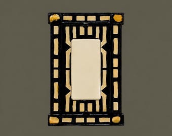 May include: A rectangular light switch wall plate featuring a glossy black finish with a geometric pattern of cream-colored accents. The design includes a central rectangular opening surrounded by a border of small, repeating cream-colored squares.