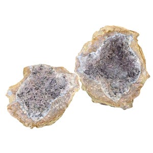 May include: Two halves of a geode, showcasing a cavity filled with small, crystalline formations. The outer shell is a light brown color, while the interior crystals are a mix of purple and white.
