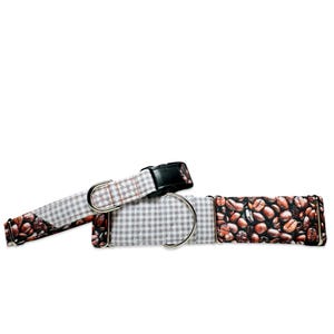 May include: A gray and white checkered dog collar with a brown and white coffee bean print. The collar has a silver buckle and a silver D-ring.