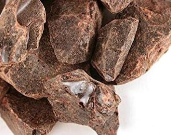 May include: Close-up of dark brown cacao nibs, a natural ingredient used in chocolate making.