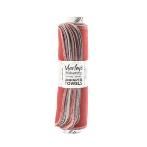 Peut inclure: Un rouleau de serviettes en tissu r&eacute;utilisables de couleur rouge, rose et gris. L'&eacute;tiquette indique "Marley's Monsters Lavables + R&eacute;utilisables Serviettes en tissu".