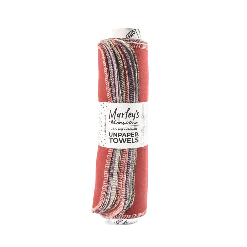 Peut inclure: Un rouleau de serviettes en tissu r&eacute;utilisables de couleur rouge, rose et gris. L'&eacute;tiquette indique "Marley's Monsters Lavables + R&eacute;utilisables Serviettes en tissu".