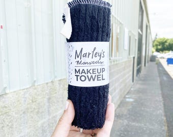 May include: Black makeup remover towel with white text that reads "Marley's Monsters MAKEUP TOWEL".