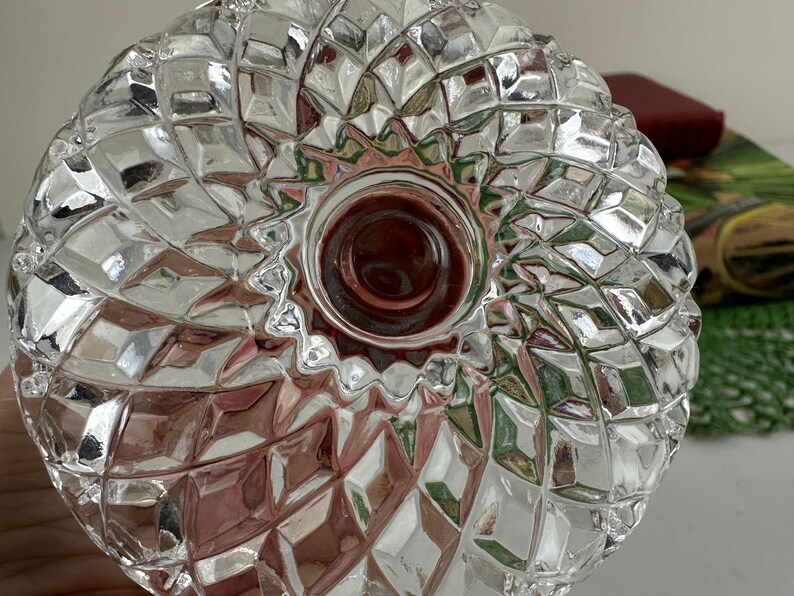 K&ouml;nnte beinhalten: Eine klare Glasschale mit einem ausgepr&auml;gten Diamantschliffmuster auf der Oberfl&auml;che. Das Design besteht aus sich wiederholenden geometrischen Facetten, die von einem glatten, kreisf&ouml;rmigen Mittelpunkt ausgehen und eine texturierte Optik erzeugen.