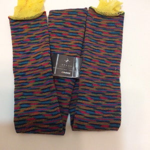 May include: A pair of colorful knit socks with a yellow top and a black tag that reads "Atlas Happy Feet" with the hobbi logo.